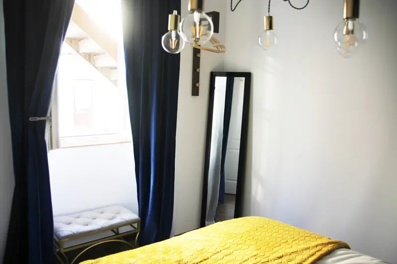 Janela com cortinas de veludo azul e banco dourado