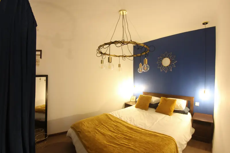 Quarto Celeste com lustre circular de lâmpadas e espelho estrela dourado