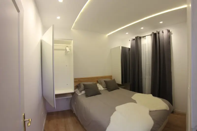 Quarto Sereno com roupeiro aberto e luz no teto