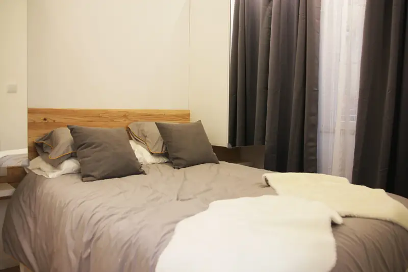 Cama com mantas brancas no Quarto Sereno