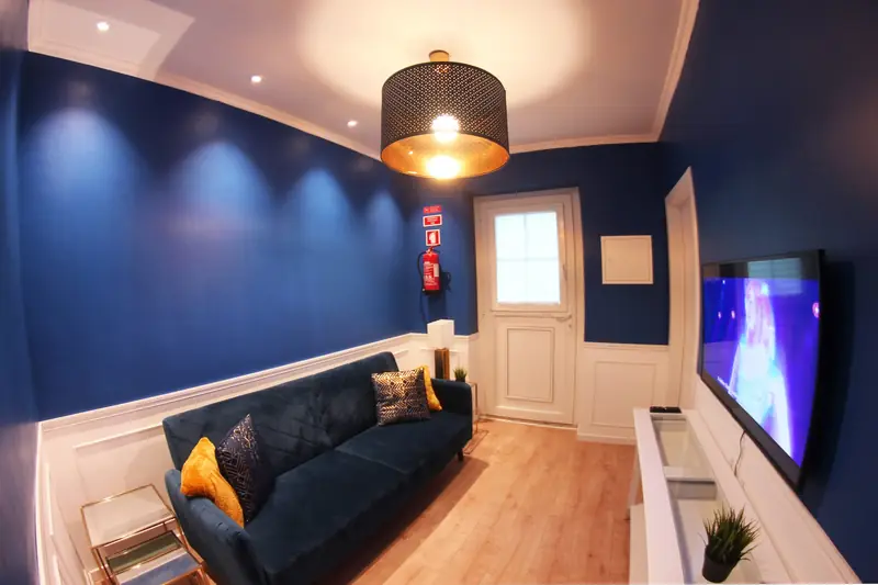 Sala com sofá azul e porta envidraçada